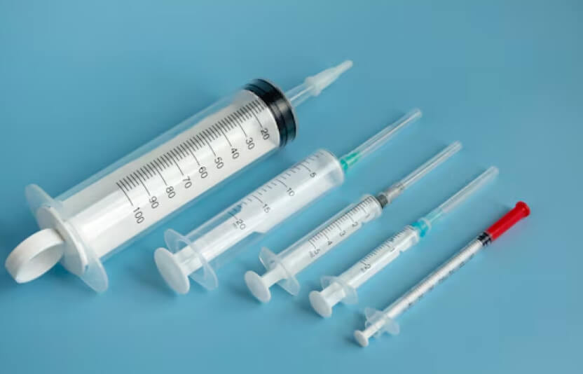 разные шприцы с прививками разложены на столе, крупным планом